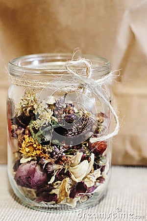 Beautiful dried flowers, different flavors, in glass jar on rust Stock Photo