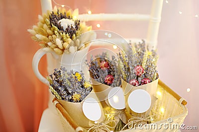 Beautiful dried flowers in paper boxes with lights on background. Wedding decorations close up Stock Photo