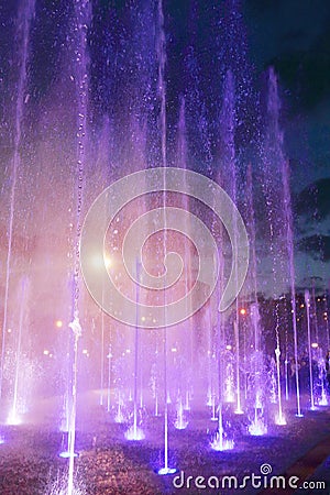 Beautiful dry fountain with bright illuminated splashes Stock Photo