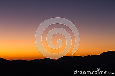 Beautiful dusk over profiles of mountains with orange and purple Stock Photo