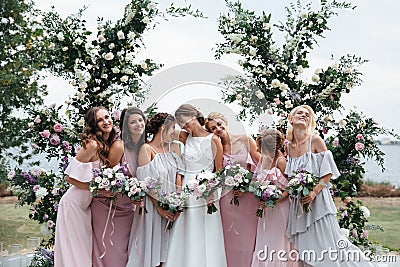 Beautiful elegant slim smiling bridesmaids in delicate pink beige summer dress on the wedding ceremony. Stock Photo