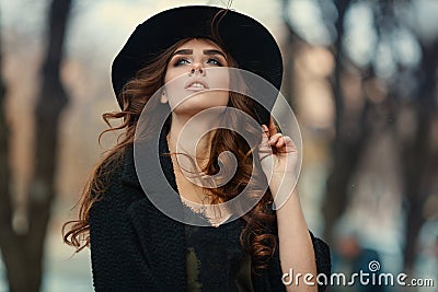 Beautiful elegant woman in black hat outdoor. Fashion look, euro Stock Photo