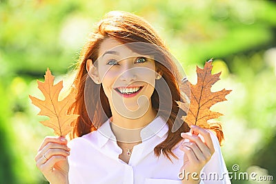 Beautiful elegant woman standing in a park in autumn. Beautiful girl walking outdoors in autumn. Smiling girl collects Stock Photo