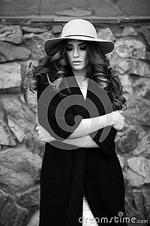 Beautiful elegant woman in stylish trendy black coat and hat ove Stock Photo