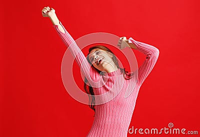 Beautiful emotional girl in pink dress on red background Stock Photo