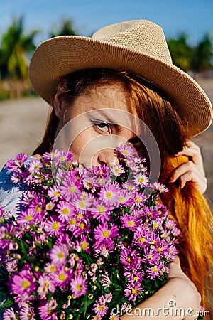 Beautiful enigmatic red hair woman in hat with flowers Stock Photo