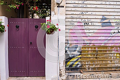 Beautiful entrance into the yard of a traditional house next to a garage door painted with graffitti in old Nicosia, Cyprus Editorial Stock Photo