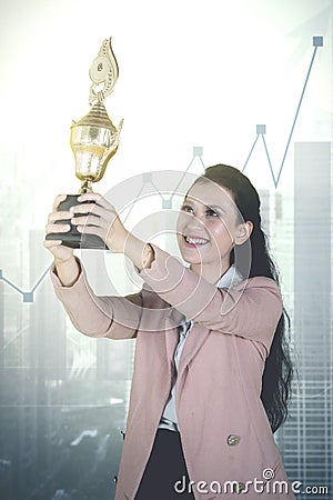 Beautiful entrepreneur lifting a trophy Stock Photo