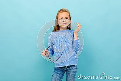 Beautiful european girl squints with glasses in hand on light blue wall Stock Photo