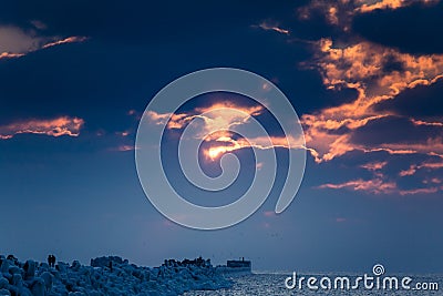 A beautiful evening landscape of a frozen breakwater in the Baltic sea. Winter landscape at the beach. Stock Photo