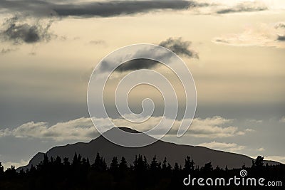 Beautiful evening light with dramatic cloudy sky, tree line in silhouette, mountain profile, Katmai National Park, Alaska, USA Stock Photo