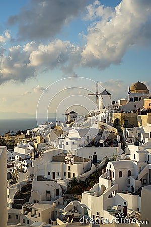 Beautiful evening light scene of Oia white building townscape and windmill along island mountain, Aegean sea, abstract cloud Editorial Stock Photo