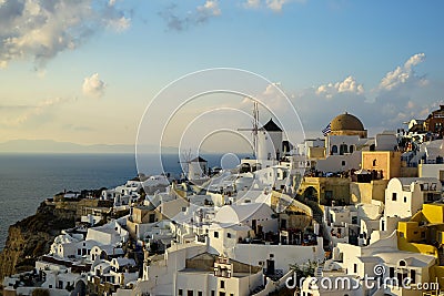 Beautiful evening light scene of Oia white building townscape and windmill along island mountain, vast Aegean sea, soft cloud Editorial Stock Photo