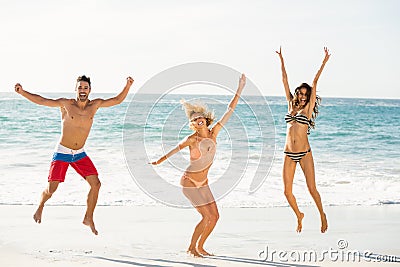 Beautiful excited friends jumping on the beach Stock Photo