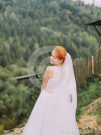 Beautiful fabulous happy redhair bride posing on the background of Carpathians mountains Stock Photo