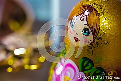 A beautiful face of Matryoshka, traditional Russian babushka doll, stacking doll, nesting doll in gold, green, yellow, pink colors Stock Photo