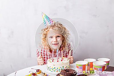 Beautiful fair-haired girl looking at the camera while sitting at the table Stock Photo