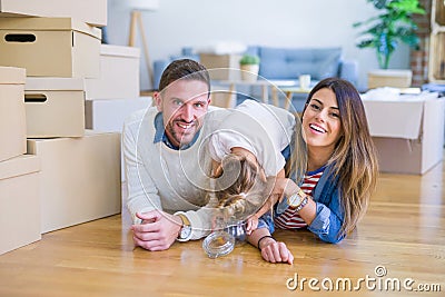 Beautiful famiily with kid lying down at new home around cardboard boxes Stock Photo