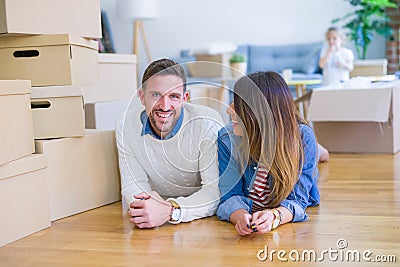 Beautiful famiily with kid lying down at new home around cardboard boxes Stock Photo