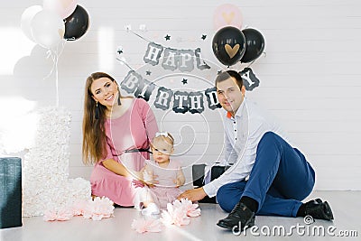 A beautiful family is celebrating their daughter`s first birthday. Photo zone for a holiday Stock Photo