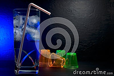 Beautiful Fancy Cocktail Drink in a Highball Glass with Blue Light and Shooter Glasses Stock Photo