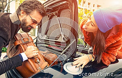 Beautiful fashion couple going to vacations, loading their car boot with leather travel suitcases - Travel fashion and hipster Stock Photo