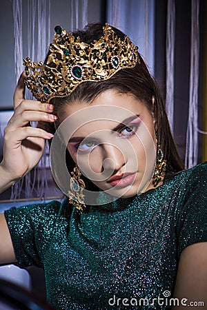 Beautiful fashion girl model with a powerful strict look in the golden crown Stock Photo