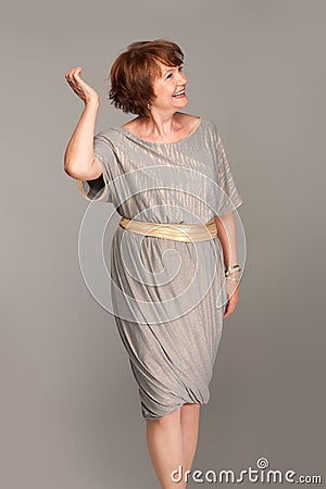 Beautiful fashionable mature woman in grey dress Stock Photo