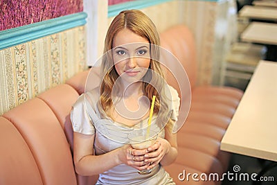 Beautiful fashionable woman girl blond in the room in a nice dress drink a coktail and smile Stock Photo