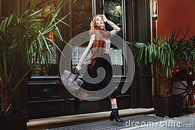 Beautiful fashionable young woman running with bag. City lifestyle. Female fashion. Full body portrait Stock Photo