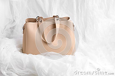 Beautiful female beige handbag on white background with soft material. spring fashion concept, copy space Stock Photo