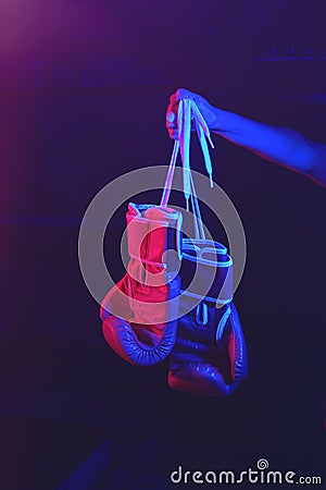 Red boxing gloves, ring with red and blue lights, industrial gym. selective focus Stock Photo