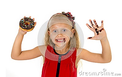 Beautiful female child with blue eyes in cute red dress eating chocolate donut with syrup stains Stock Photo