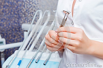 Beautiful female doctor with stomatological tools against dental equipment. Dentist background Stock Photo