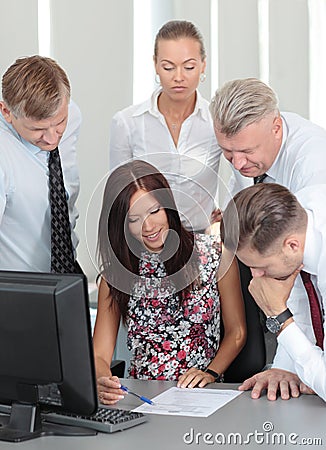 Beautiful female executive pointing at laptop scre Stock Photo