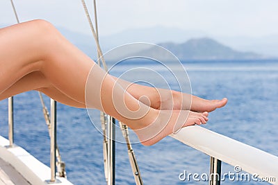 Beautiful female feet against the sea cruise landscape. Rest on a yacht Stock Photo
