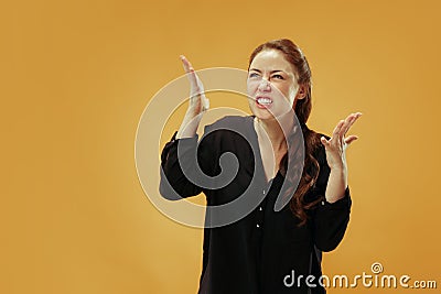 Beautiful female half-length portrait isolated on gold studio backgroud. The young emotional surprised woman Stock Photo
