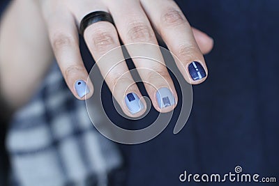 Beautiful female hand with extraordinary manicure. Creative nail design in blue. Ultra stylish colors of nail polish. Stock Photo