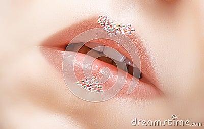 Beautiful female pink lips with glittering gems art decoration. Pink lipsgloss with bright jewel stones decor Stock Photo