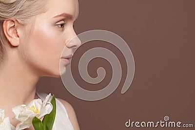 Beautiful female profile white flowers on brown background Stock Photo