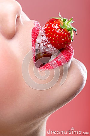 Beautiful female red lips, full with Granulated Sugar, biting a strawberry Stock Photo