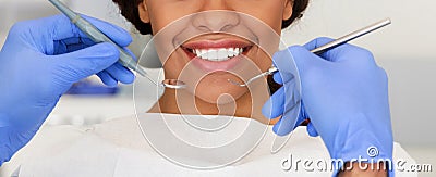 Beautiful female smile and dentist hands with tools Stock Photo