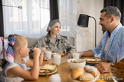 Beautiful female soldier spending morning with husband and daughter Stock Photo