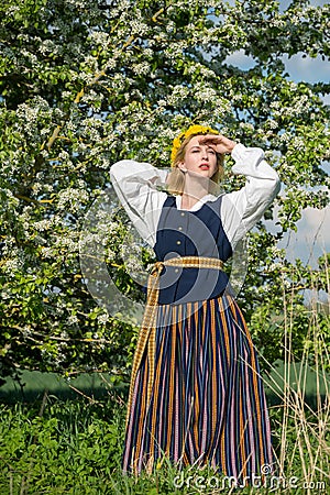 Beautiful feminime woman in national dress with white spring flowers Stock Photo