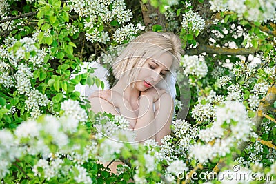 Beautiful feminime woman with white wings with white spring flowers. Stock Photo