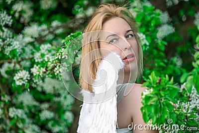 Beautiful feminime woman with white wings with white spring flowers. Stock Photo