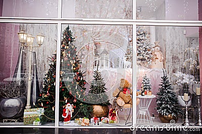 Beautiful festive Christmas storefront with decorated artificial Christmas trees and toys Stock Photo