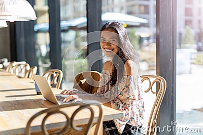 Beautiful Filipino woman using laptop at cafe Stock Photo