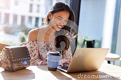 Beautiful Filipino woman using laptop at cafe Stock Photo