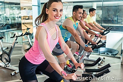 Beautiful fit woman smiling during cardio workout at indoor cycl Stock Photo